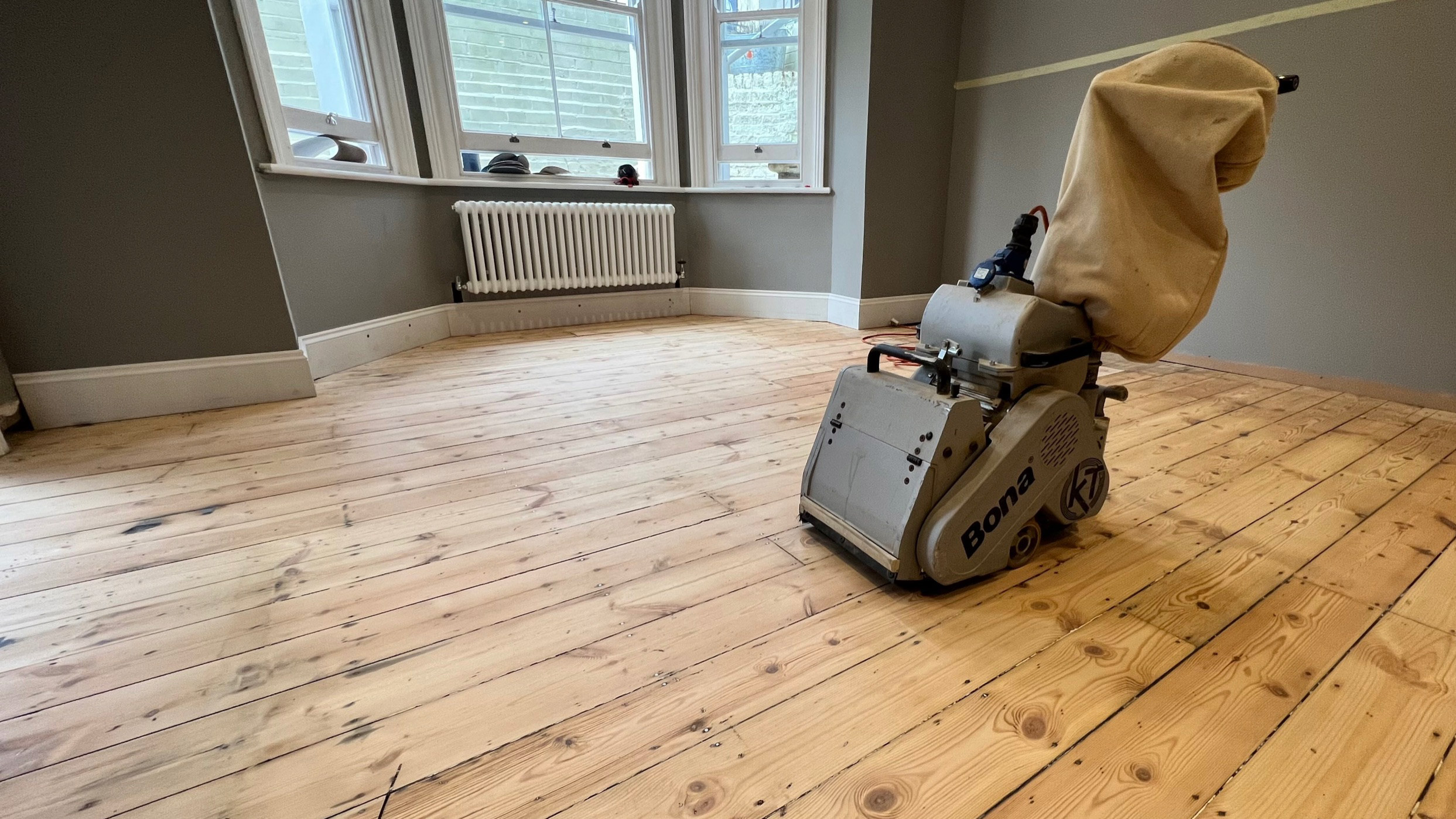 Mark Antony & Sons are Kent's leading floor sanding experts. Image shows a wooden floor in a Tunbridge Wells home with a professional dust-free Bona sander.