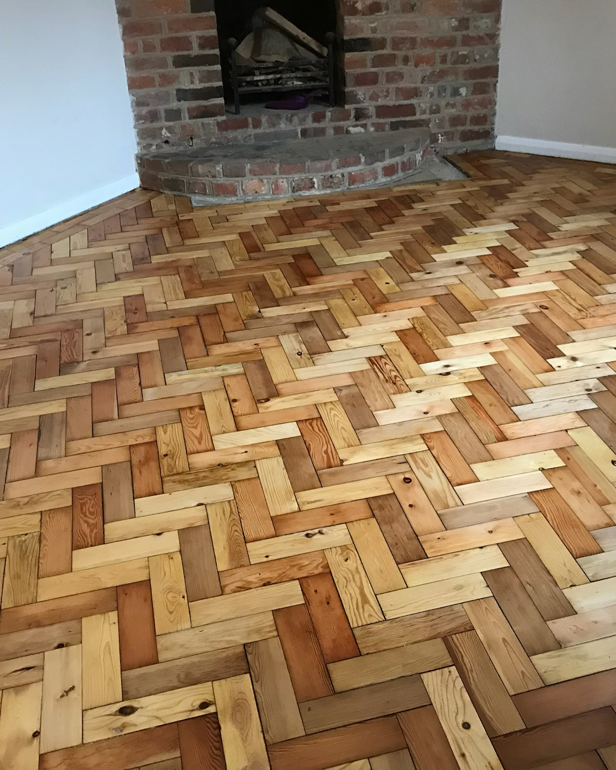 Image shows freshly sanded and refinished parquet flooring in a home in Kent.